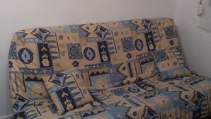 Un sofá estampado con un estante decorativo encima.