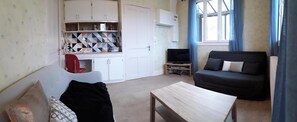 Cozy living space with a kitchenette, sofa, and TV.