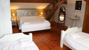 Ein Schlafzimmer mit einem großen Bett, zwei Einzelbetten, einem Spiegel, einem Waschbecken und einer Wand mit einem Schild.