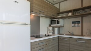 A modern kitchen with a built-in microwave, coffee maker, and a stainless steel sink. - Farniente in Martinique (Le Vauclin)