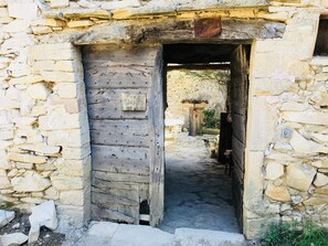 A stone building with a wooden door leading into a courtyard. - In a small Mas with character ... (Entrechaux)