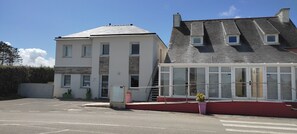 Un bâtiment doté d’un toit plat, d’une grande section vitrée et d’un escalier menant à l’entrée.
