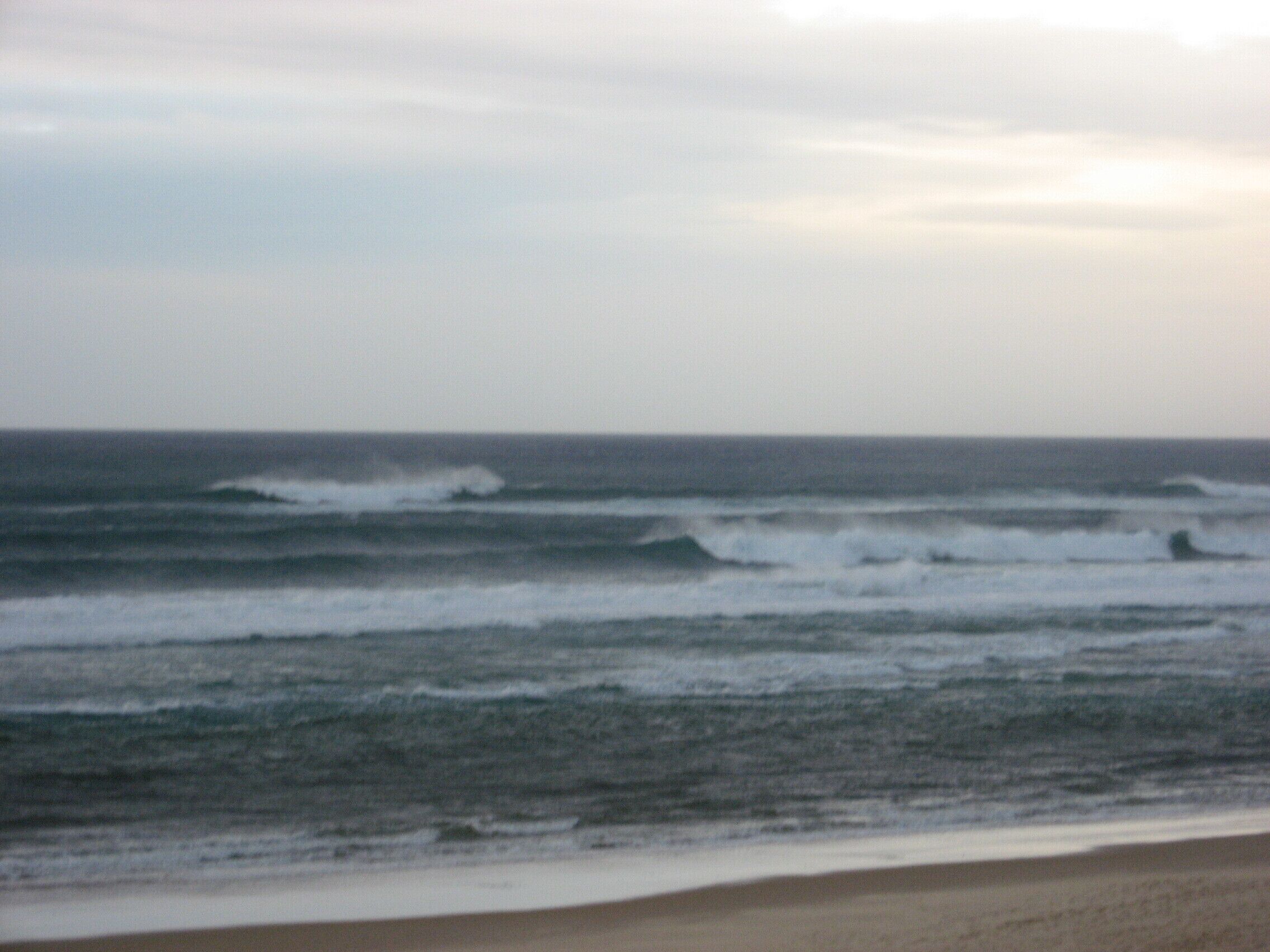 A beach with waves approaching the shore.