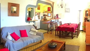 A living room with a sofa, a coffee table, and a dining area with a table and chairs. - The press house (minerve)