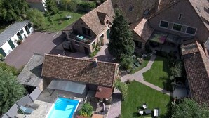 Vue aérienne d’un quartier résidentiel avec plusieurs maisons, une piscine et une pelouse bien entretenue.