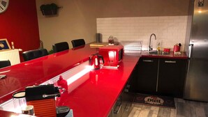 A modern kitchen with a red countertop, stainless steel appliances, and a white tiled backsplash. - Jacques' workshop (Villy)