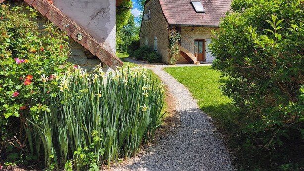 A stone building with a gravel path leading to a wooden staircase.