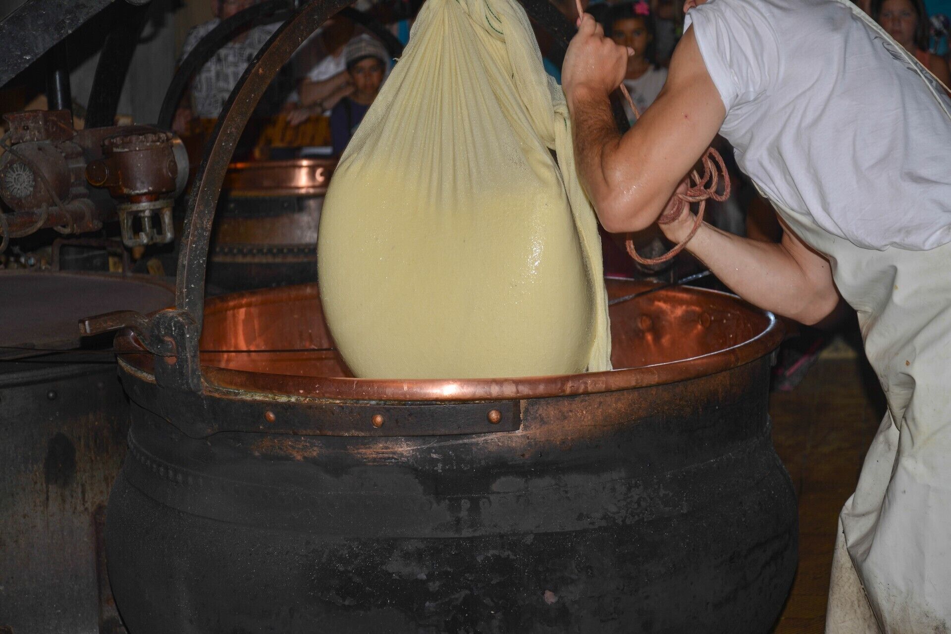 Une personne tenant un grand sac au-dessus d’une marmite en cuivre.