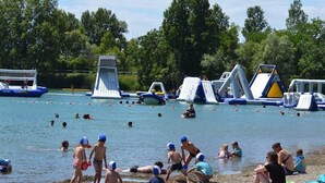 A beach with inflatable water slides and swimming activities.