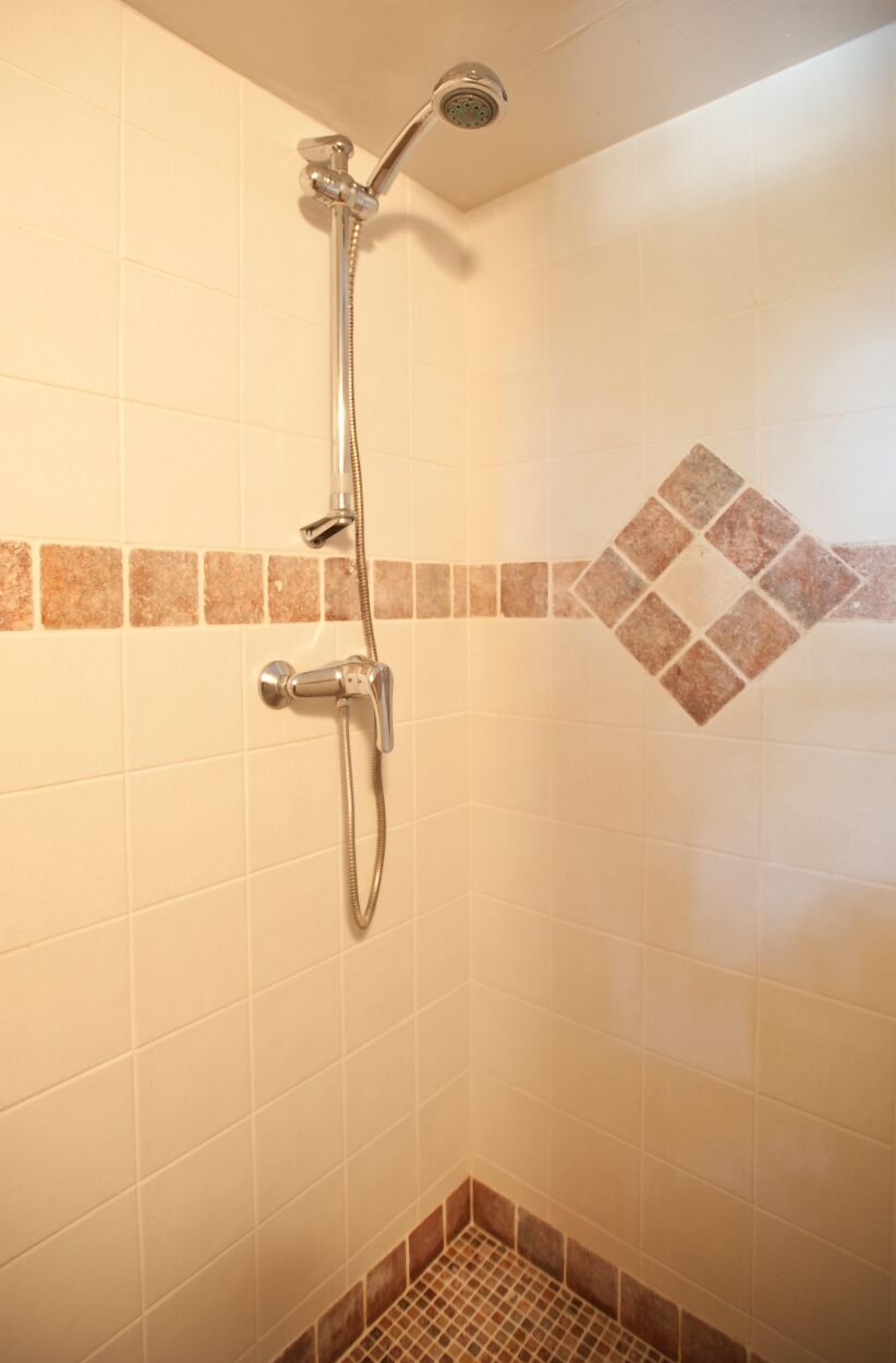 Ducha con cabezal de ducha manual y llave de pared.