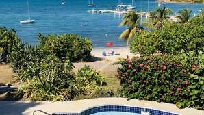 Área da piscina com vista para o oceano e barcos atracados.