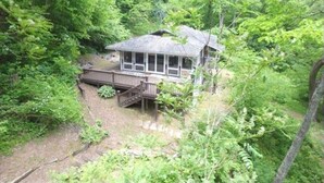 Eine Hütte, umgeben von dichtem Wald.