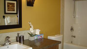 Een bad/douchecombinatie, een haardroger, handdoeken