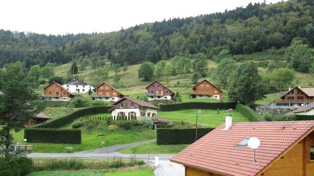 A wooden cabin with a red roof, surrounded by a well-maintained lawn and a picnic table. - Duplex "La Ferme de Paul" 6 Pers. + baby - Altitude 800 m'at 2 km Ski slopes (La Bresse)