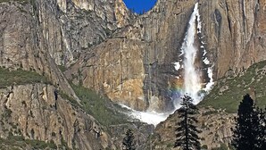 Una cascada se precipita por un acantilado rocoso rodeado de zonas boscosas.