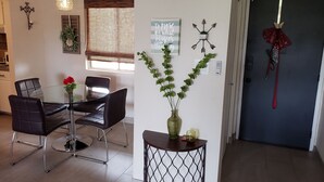 A dining area with a glass table and black chairs, a decorative plant, and a sign on the wall. - Old Town Scottsdale Getaway - Spectacular Pool View (Scottsdale)