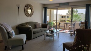 A living room with a sofa, armchair, coffee table, and a ceiling fan. - Old Town Scottsdale Getaway - Spectacular Pool View (Scottsdale)
