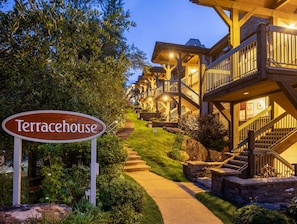 A sign labeled 'Terracehouse' with a pathway leading to a building with multiple balconies and a wooden exterior.