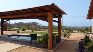 A covered outdoor area with a pool, seating, and potted plants. - Casa Habanero - Ocean View, whole house by Troncones Point  (Troncones)
