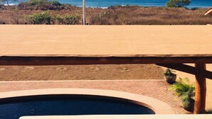 A pool area with a view of the ocean and a wooden deck. - Casa Habanero - Ocean View, whole house by Troncones Point  (Troncones)