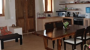 A spacious living area with a wooden dining table, chairs, a sofa, and a ceiling fan. - Casa Habanero - Ocean View, whole house by Troncones Point  (Troncones)