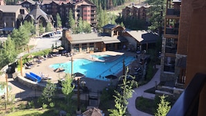 A resort with a central pool, multiple buildings, and a mountainous backdrop. - Surrounded by pine trees and mountains (Truckee)
