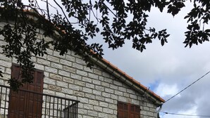 A stone building with a balcony, wooden shutters, and a door. - Detached house (Large private garden) (Petreto-Bicchisano)