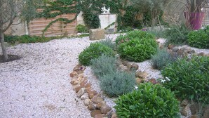 A garden with a variety of plants and a decorative stone structure. - Country house with private heated pool 15mn from the sea (Vendres)