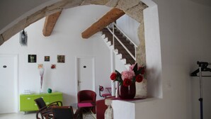 A room with a staircase, a green cabinet, a red chair, and a vase with flowers. - Country house with private heated pool 15mn from the sea (Vendres)