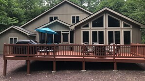 A two-story building with a deck and outdoor seating area.