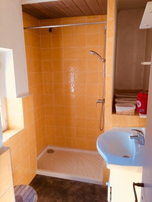 A bathroom with a shower, a sink, and a toilet.