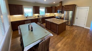 Una cocina moderna con armarios de madera oscura, electrodomésticos de acero inoxidable y una isla central.