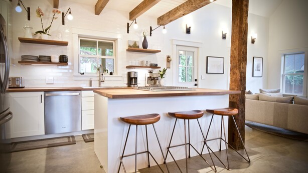 A modern kitchen with white cabinetry, a wooden island with bar stools, and pendant lighting. - New! Vermont modern farmhouse in Stowe Village (Stowe)