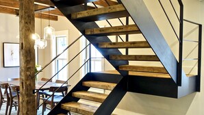 A modern staircase with wooden steps and black metal railings, leading to an upper floor. - New! Vermont modern farmhouse in Stowe Village (Stowe)