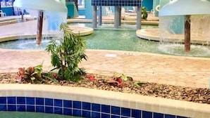 An indoor swimming pool with two water features, surrounded by tiled walls and pillars. - Impeccable Oceanfront Suite Top Floor (Myrtle Beach)