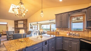 A modern kitchen with granite countertops, dark blue cabinets, and a large island.