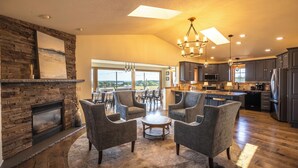 A spacious living room with a fireplace, comfortable seating, and a large window overlooking a scenic view.