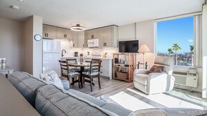 A modern kitchen with a dining area, a sofa, and a chair.