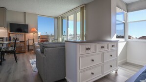 A modern living room with a grey sofa, a white dresser, and a flat-screen TV.