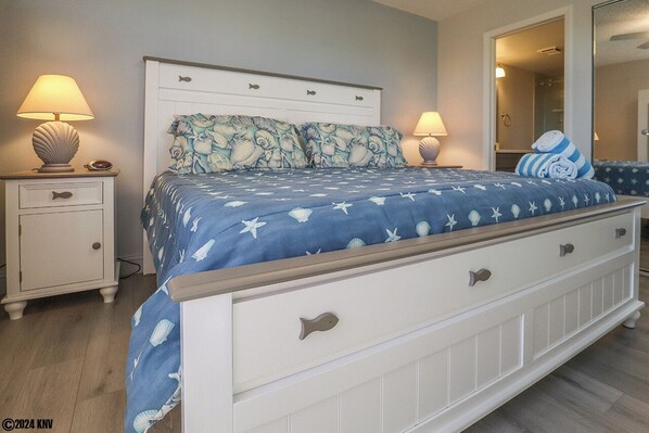A bedroom with a bed, two bedside tables, and a nightstand.