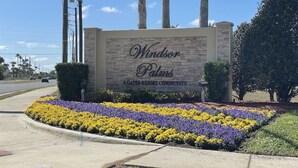 Windsor Palms -niminen, aidattu lomakohde, ja sen edessä on kauniisti suunniteltu kukkapenkki.