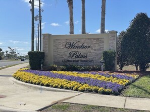 Welcome to Windsor Palms, a gated community with beautifully maintained gardens and a clear entrance sign.