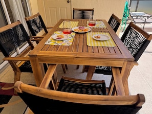 Enjoy a meal al fresco at this outdoor dining area, complete with a table and chairs.
