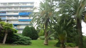 A multi-story building with balconies, surrounded by well-maintained greenery and palm trees. -  Antibes nice 3 rooms, clear and bright, beautiful sea view and swimming pool (Antibes)