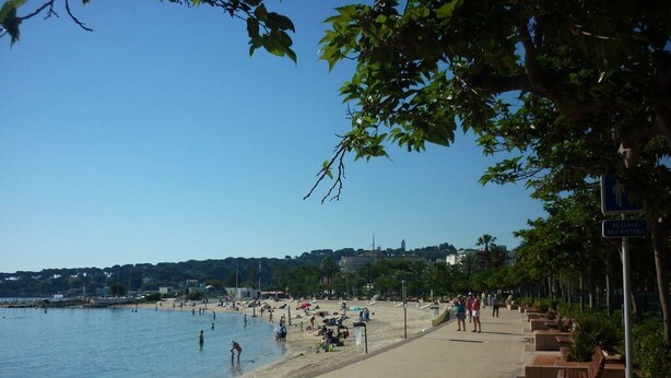 A beach with a paved walkway, benches, and a clear view of the water. -  Antibes nice 3 rooms, clear and bright, beautiful sea view and swimming pool (Antibes)