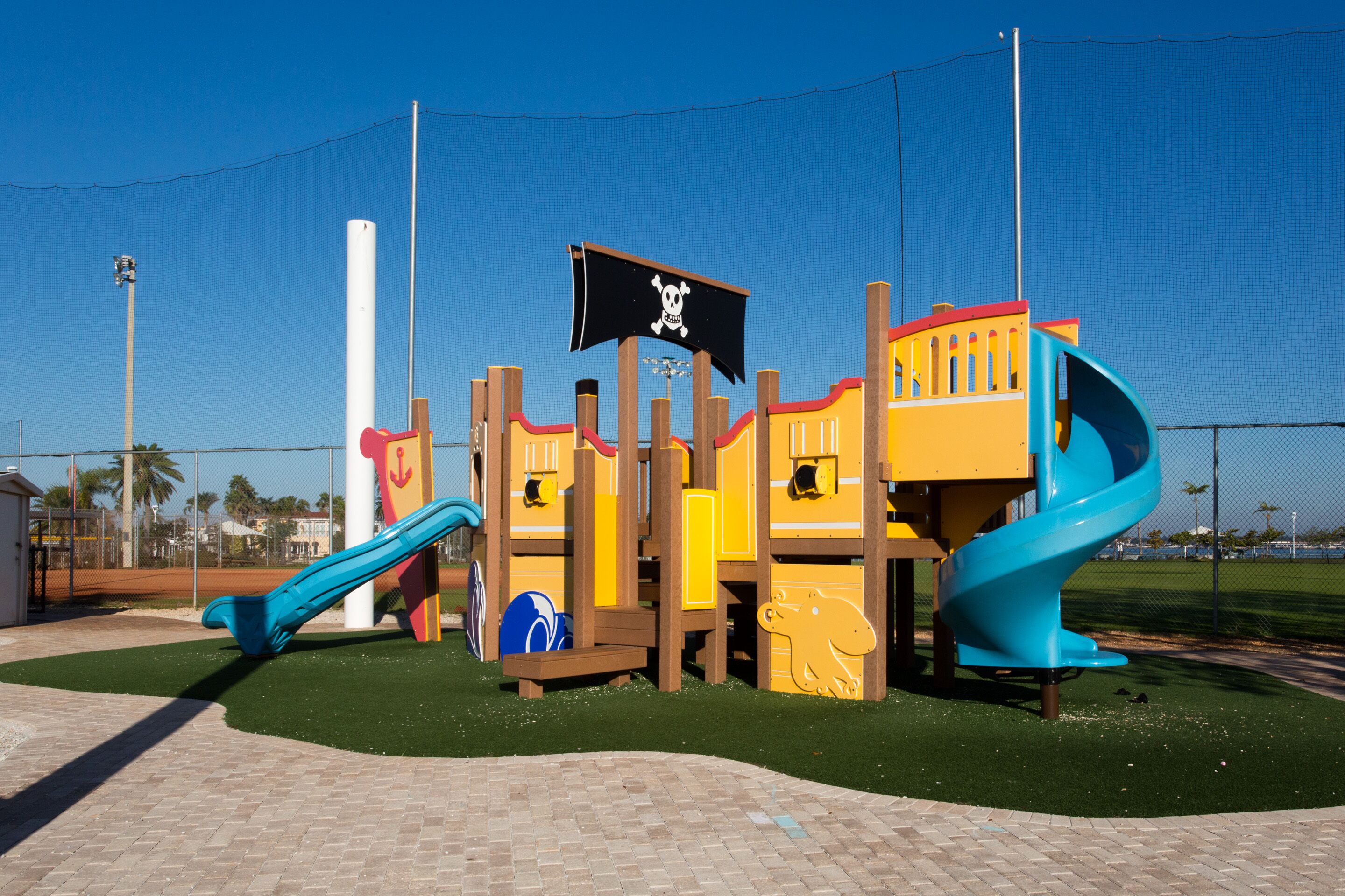 Une aire de jeux dotée d’une structure ludique sur le thème des pirates, comprenant des toboggans et des zones d’escalade.