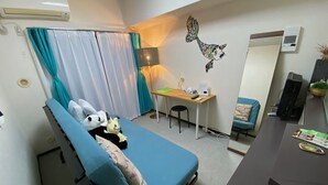 A compact room with a bed, a desk, and a chair. There is a mirror on the wall, a lamp, and a small table with a plant. - Today's Relaxing and Fun Studio! Near Olympic Park! (Setagaya)