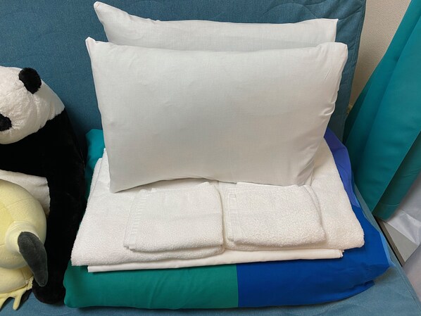 A neatly folded white pillow on a bed with a teal and blue blanket. - Today's Relaxing and Fun Studio! Near Olympic Park! (Setagaya)