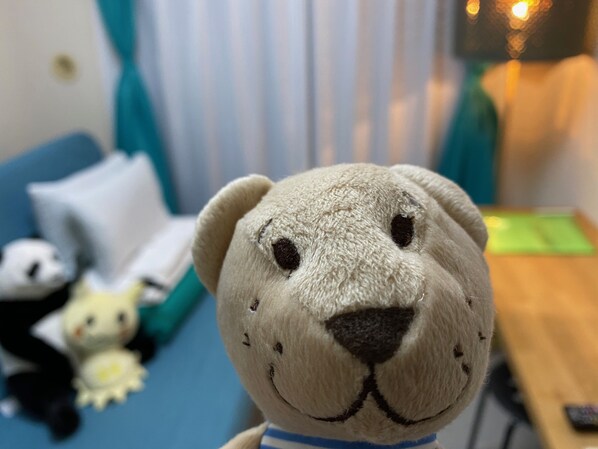 A plush toy bear on a blue couch with a white pillow and a small stuffed animal in the background. - Today's Relaxing and Fun Studio! Near Olympic Park! (Setagaya)