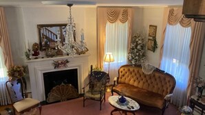 Un salon traditionnel avec une cheminée, un lustre, un canapé et une table basse.